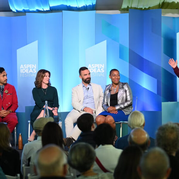 Panelists seated on stage at the Aspen Ideas Festival, audience in foreground.